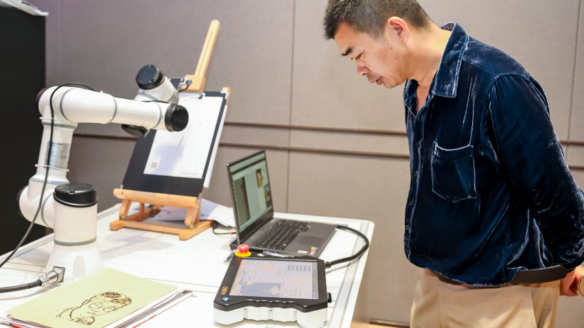 嘉賓體驗遨博AI繪畫機器人。主辦方供圖